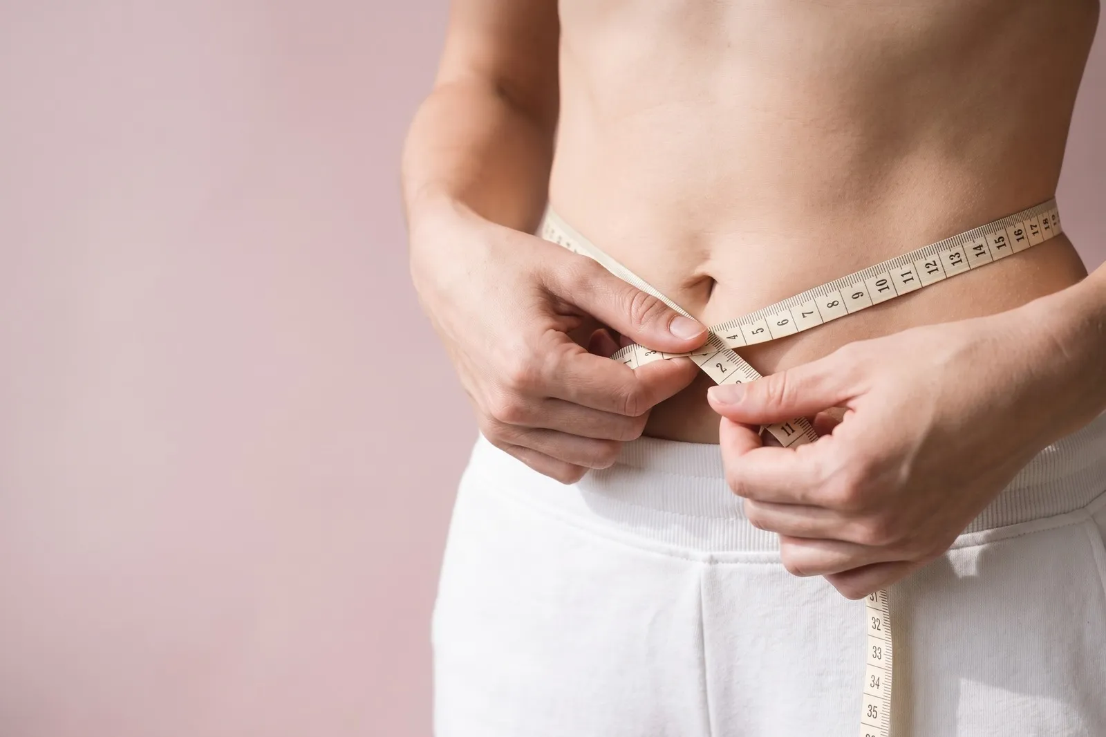 A waist being measured with a cloth tape