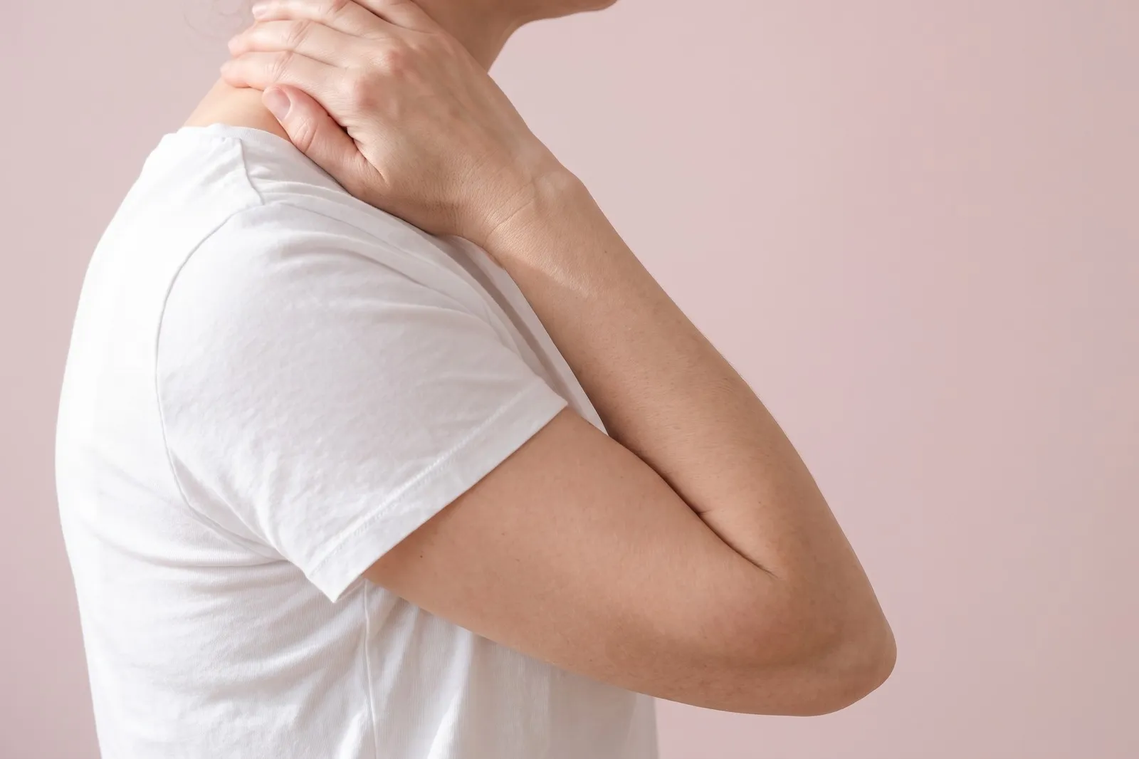 A hand reaching to the back of the neck, shoulders dropped
